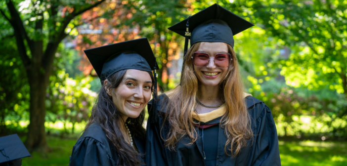 frankie heppell (right) with MSW graduate Caitlin Kreutz smile for a photo on graduation day