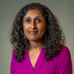 a headshot of ancy lewis. she wears a purple shirt. 