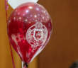 a maroon balloon with the fordham seal in white on it.