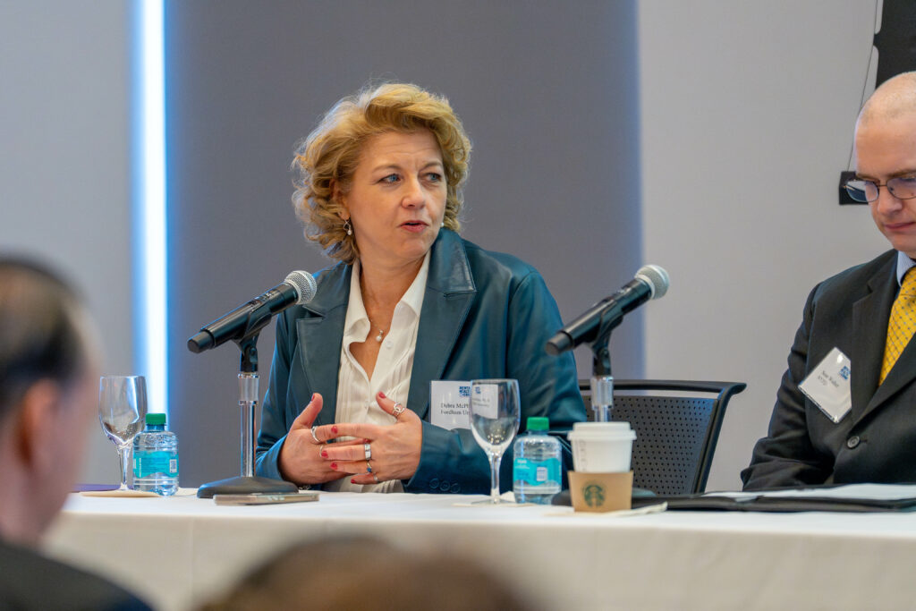 dean debra mcphee moderates the first panel. she wears a blue jacket with a white shirt.
